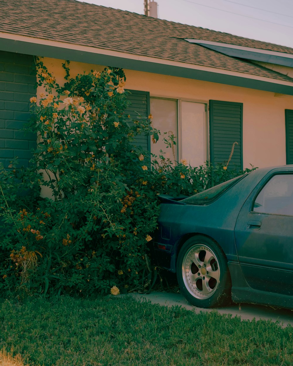 a green car parked in front of a house