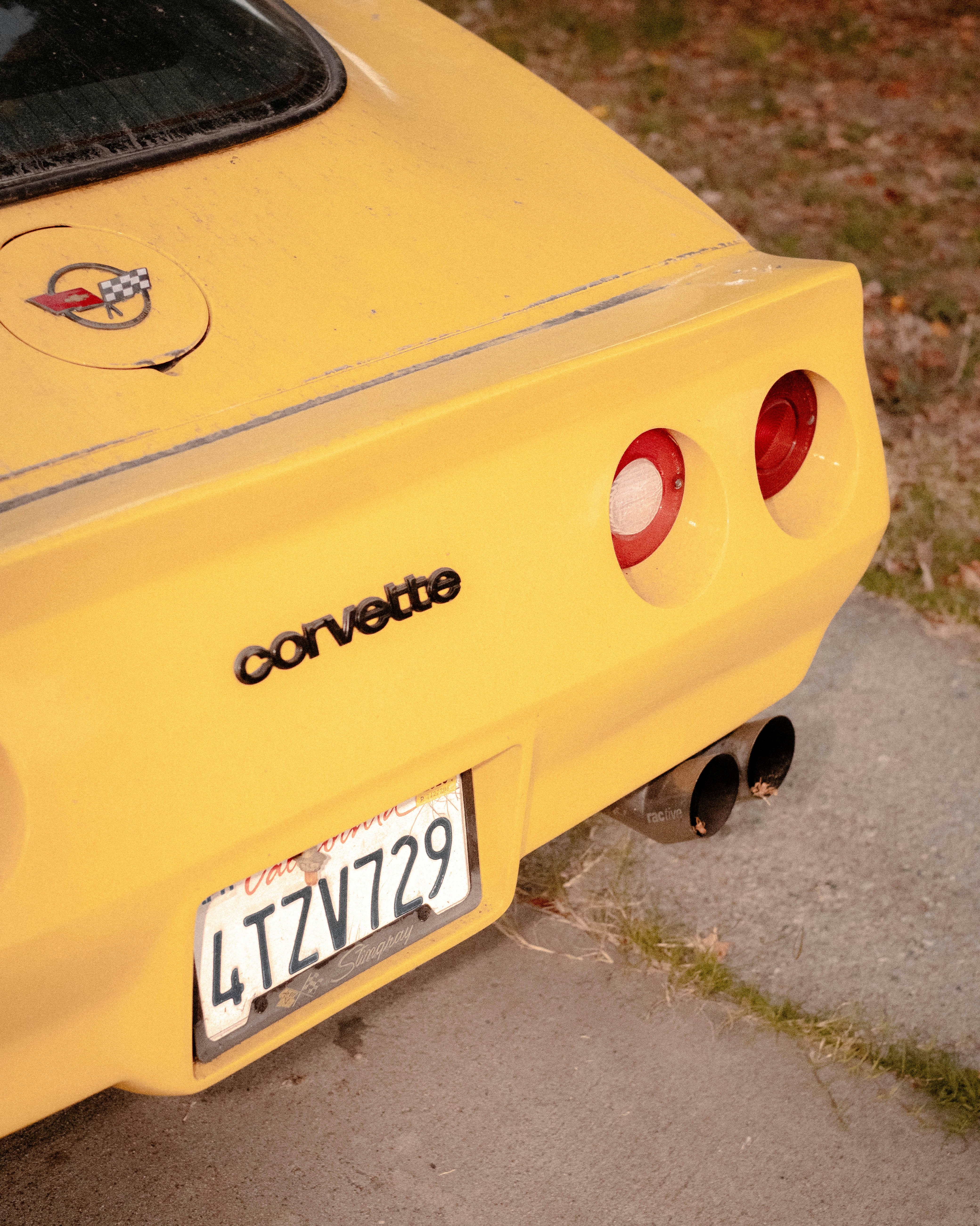 a close up of the rear end of a yellow sports car