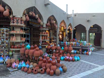 A close-up of traditional Omani pottery displayed in a vibrant Nizwa market.