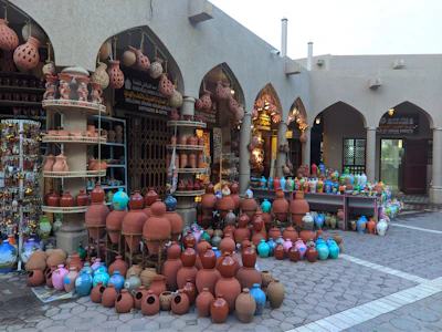 A close-up of traditional Omani pottery displayed in a vibrant Nizwa market.