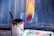 A close-up of a paintbrush dipping into a vibrant paint can, ready for use.