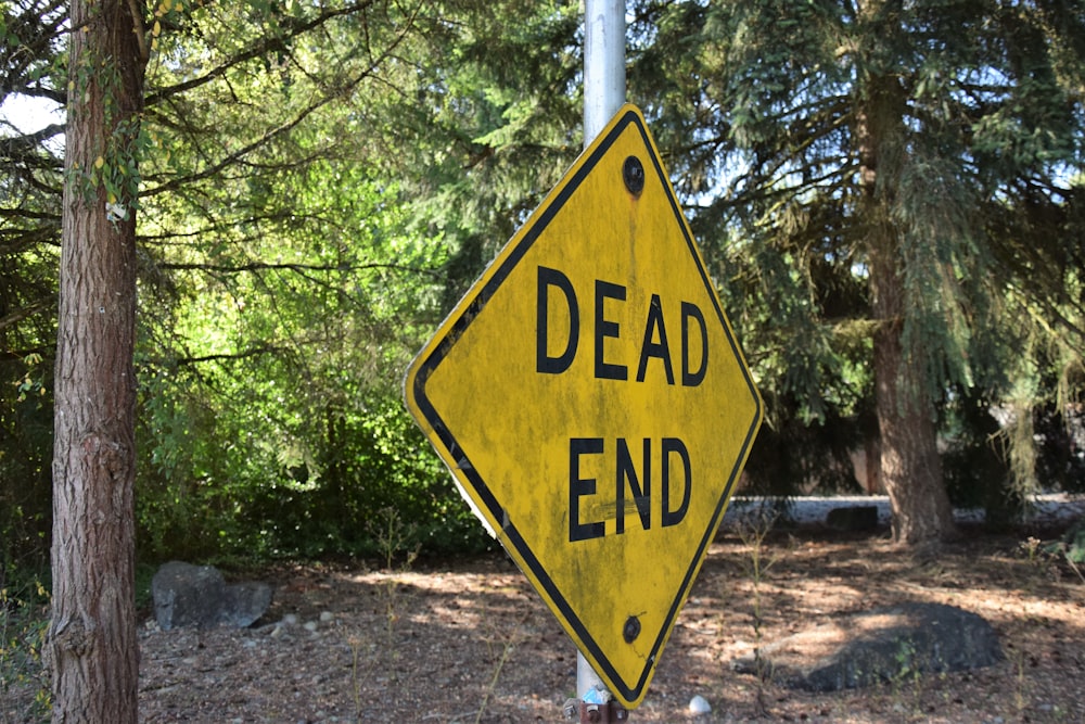 a dead end sign hanging from the side of a pole