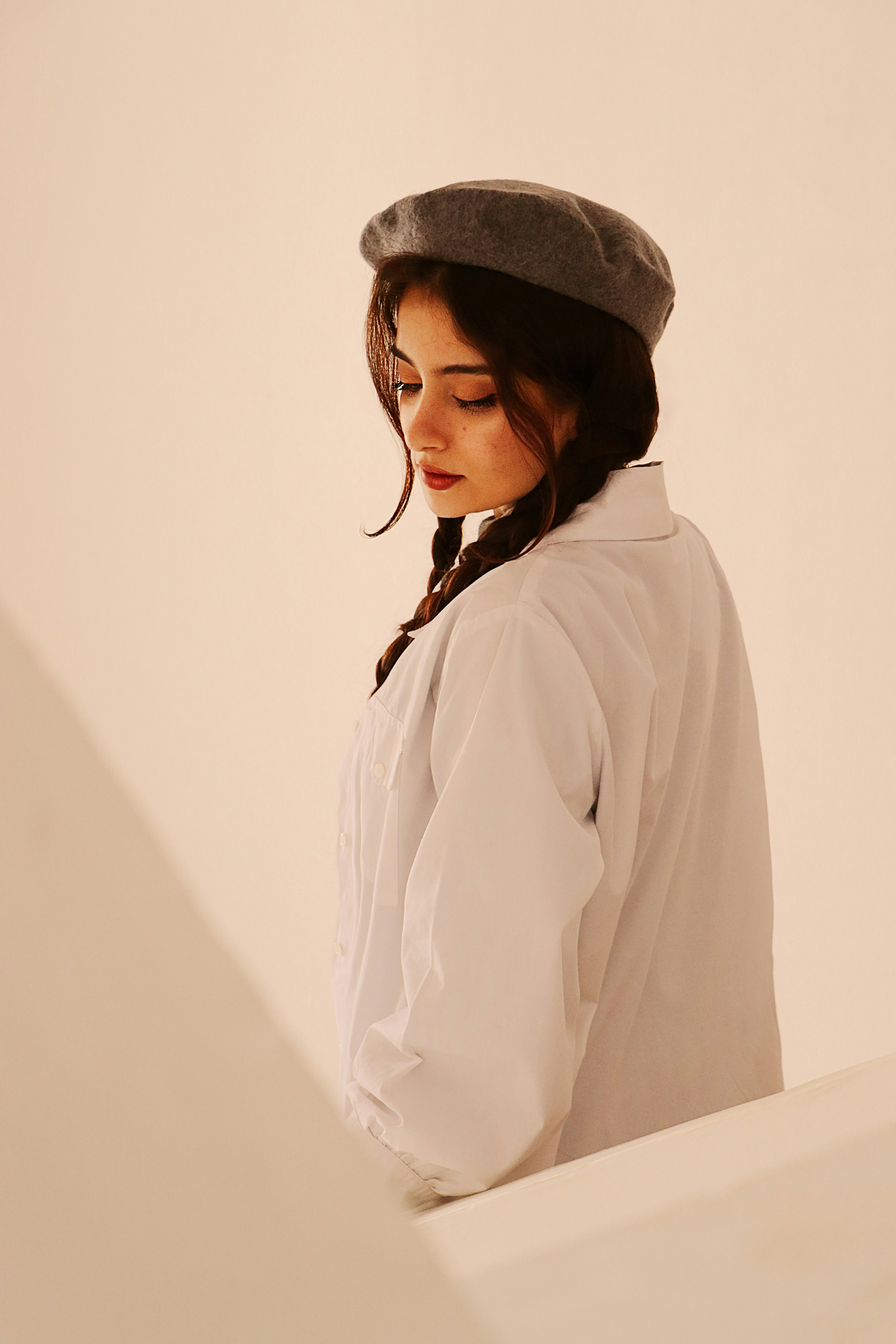 a woman in a white shirt and a gray hat