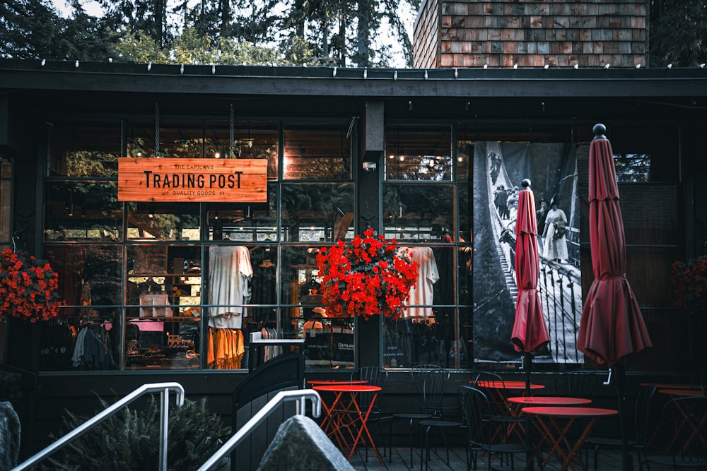 a store front with red chairs and umbrellas