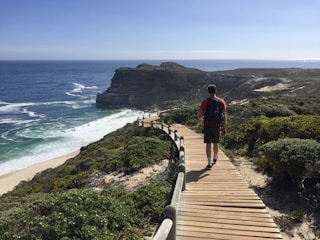 A traveler walking along a scenic Indonesian coastal path with a backpack, symbolizing the journey from Sabang to Merauke.