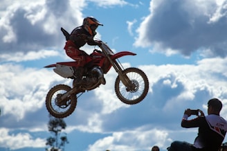 A dramatic shot of a bike jumping over a rocky terrain.