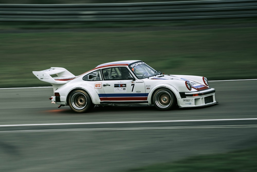 a white car driving down a race track