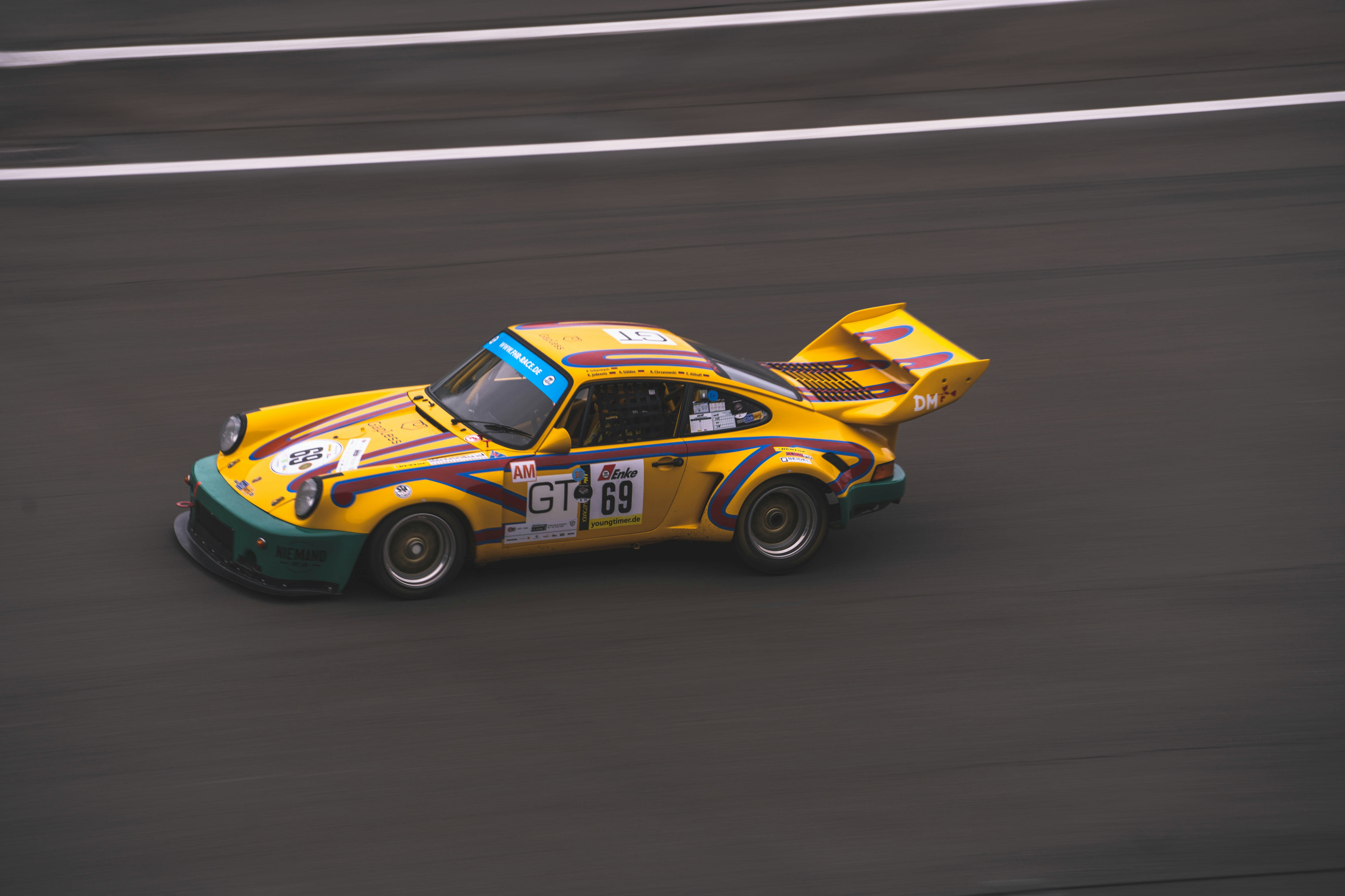 a yellow race car driving down a race track