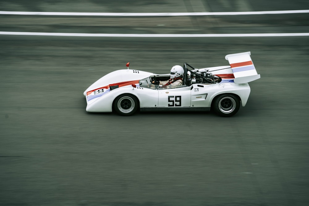 a white race car driving down a race track