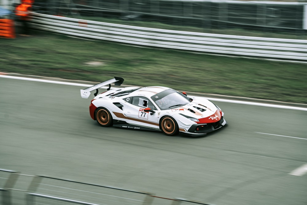 a white sports car driving down a race track