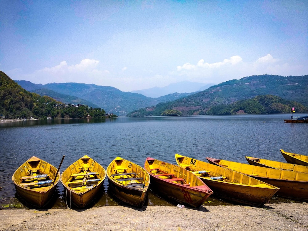 a group of yellow boats sitting on top of a lake
