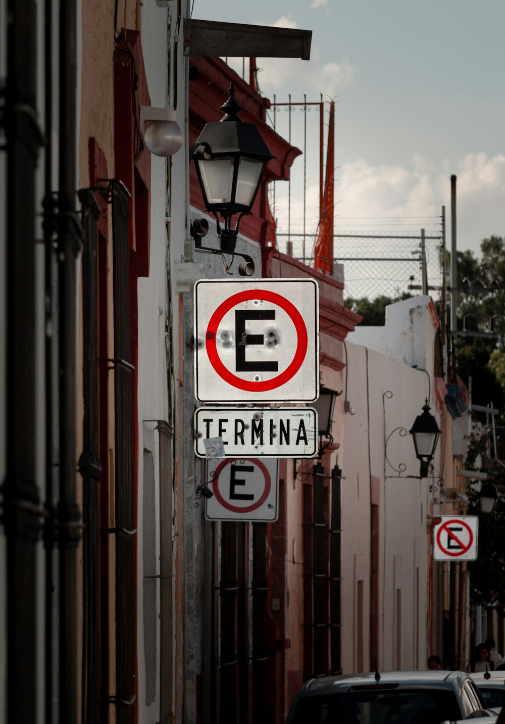 a red and white street sign hanging from the side of a building