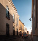 a car is parked on a cobblestone street