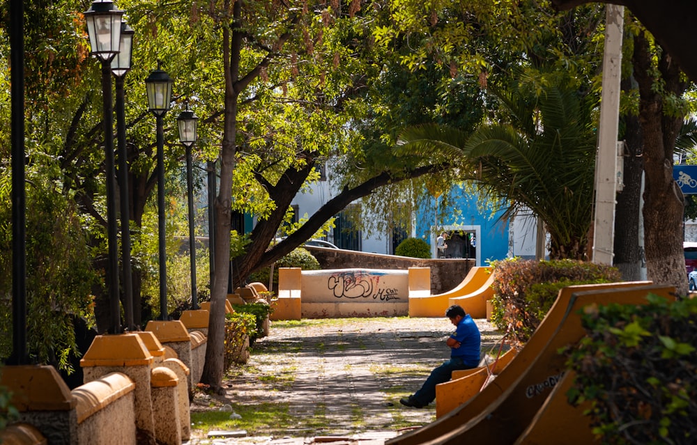 a person sitting on a bench in a park