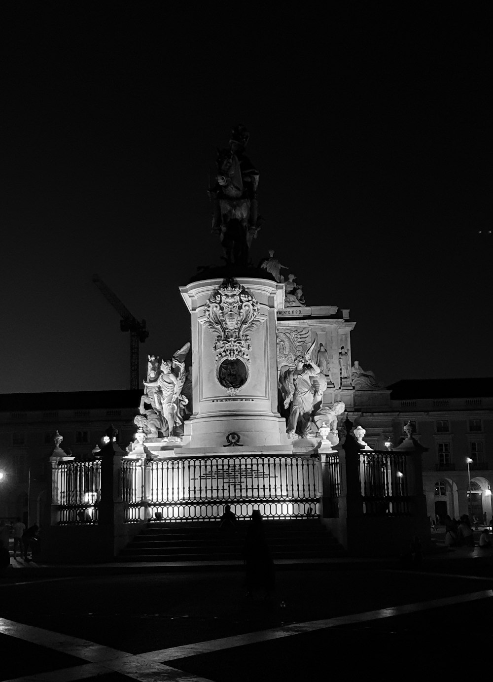 Una foto en blanco y negro de una estatua por la noche