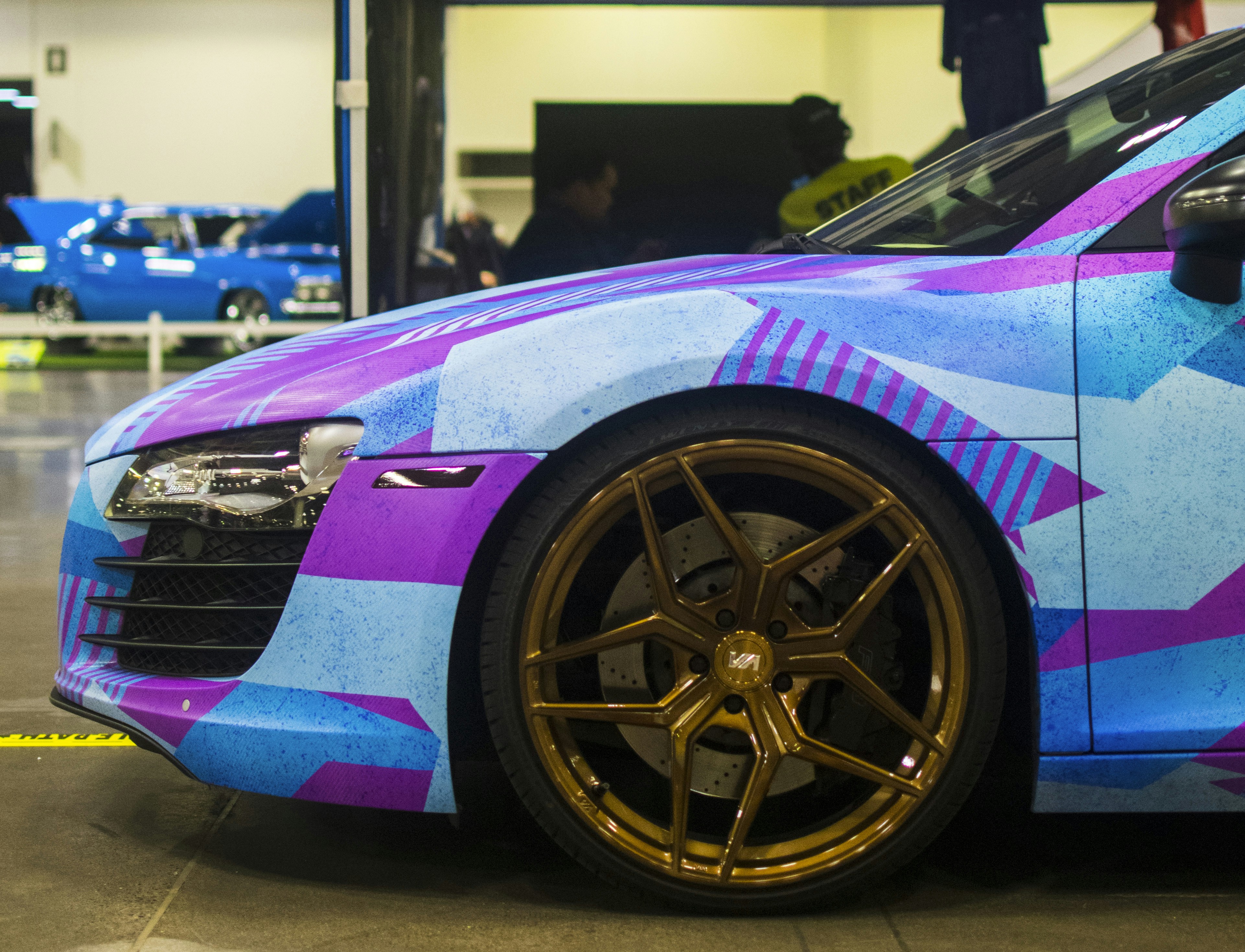 a purple and blue car with gold rims