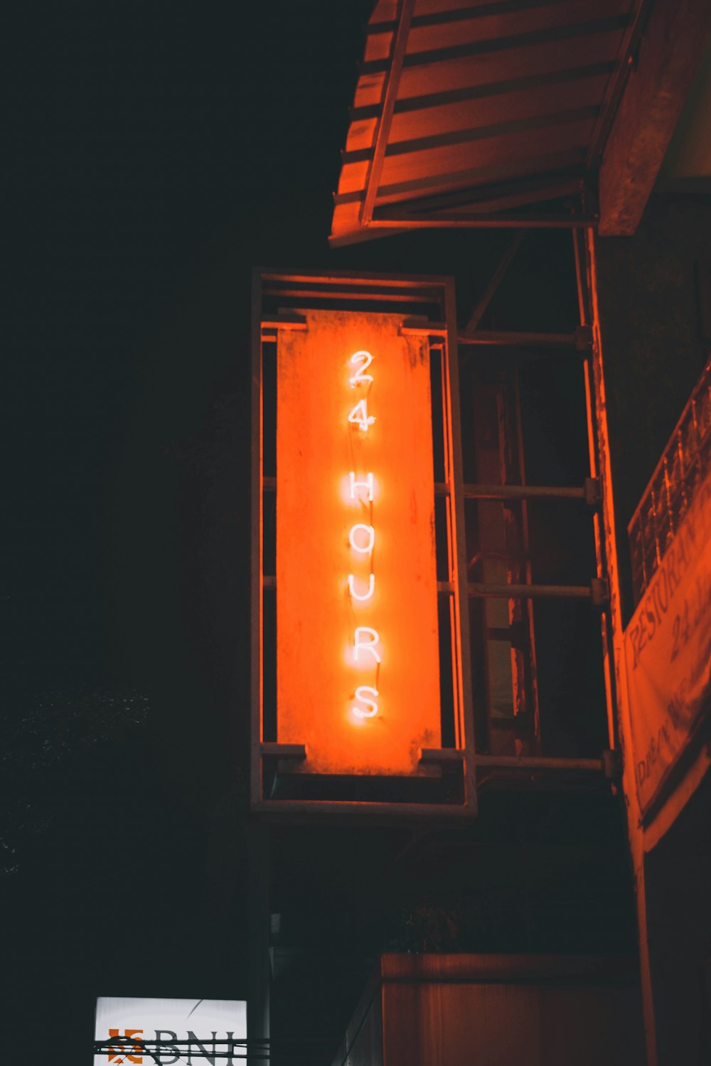 a neon sign on a building with a ladder
