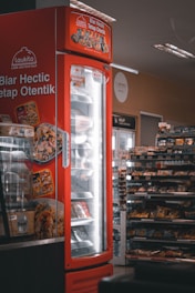 a red refrigerator with food inside of it