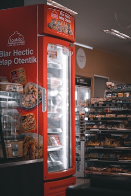 a red refrigerator with food inside of it