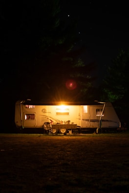 Nighttime shot of a campground 21st century modular home illuminated softly from inside.