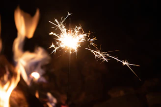 Close-up of green sparkler flames flickering in the dark, showcasing government-approved safety.