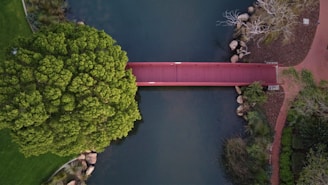 Aerial view of a completed bridge project spanning a river in a lush green landscape