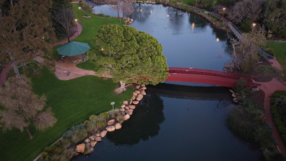 an aerial view of a red bridge over a river