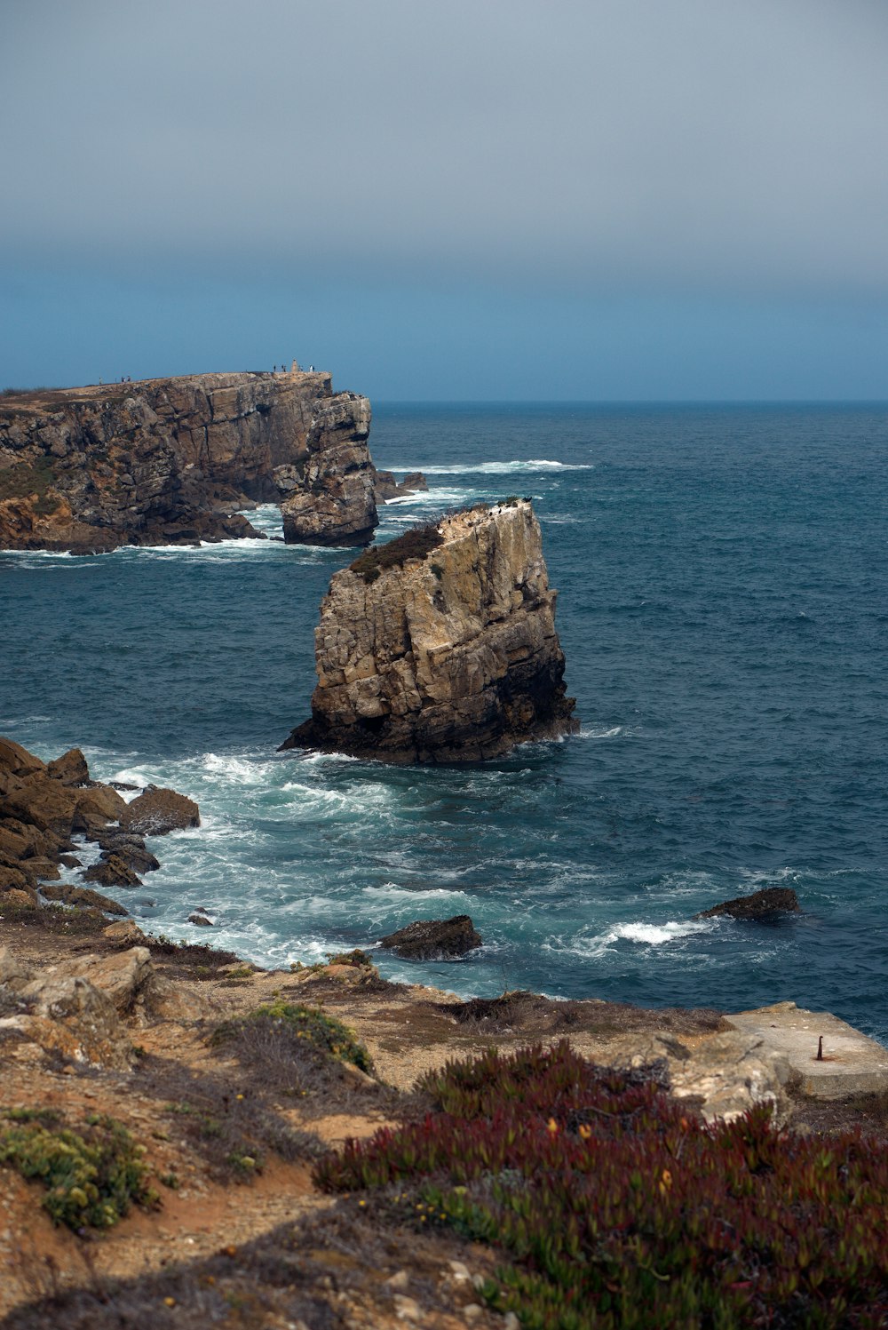 a large rock outcropping in the middle of the ocean