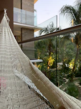 Sunlit veranda with hammocks and tropical plants inviting relaxation.