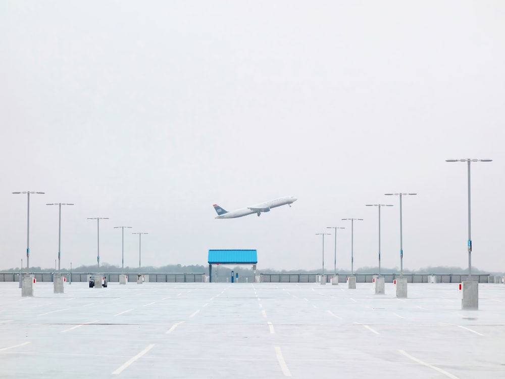 an airplane is flying over a parking lot