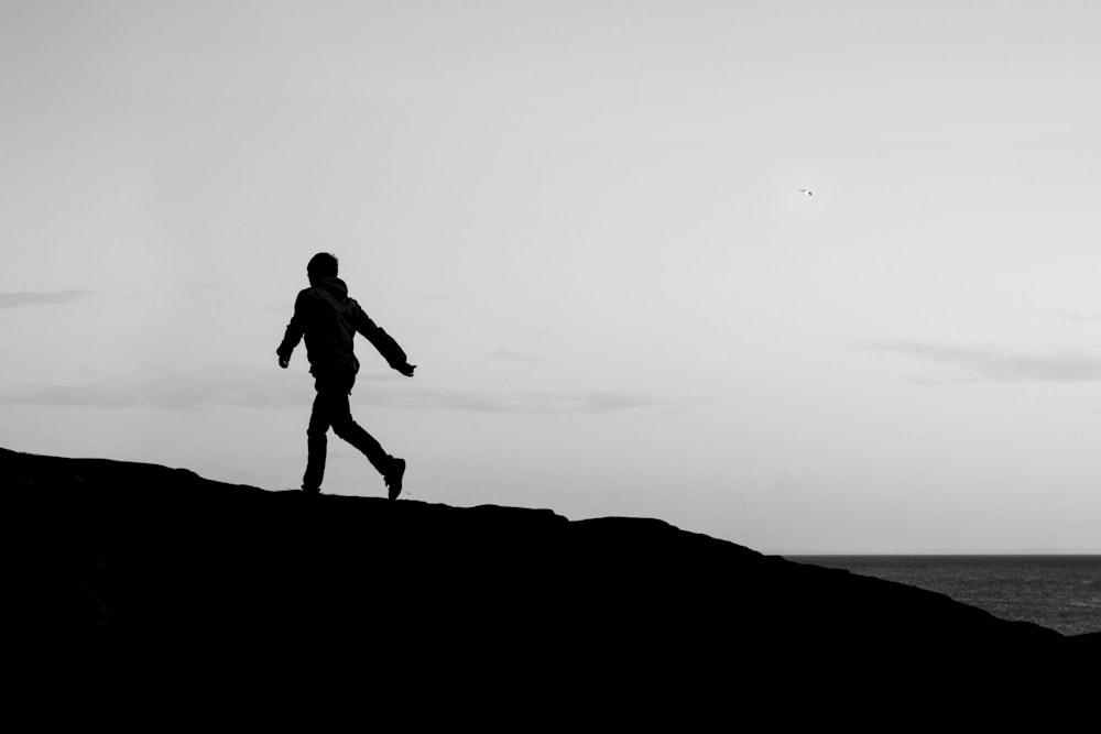 a person standing on top of a hill near the ocean