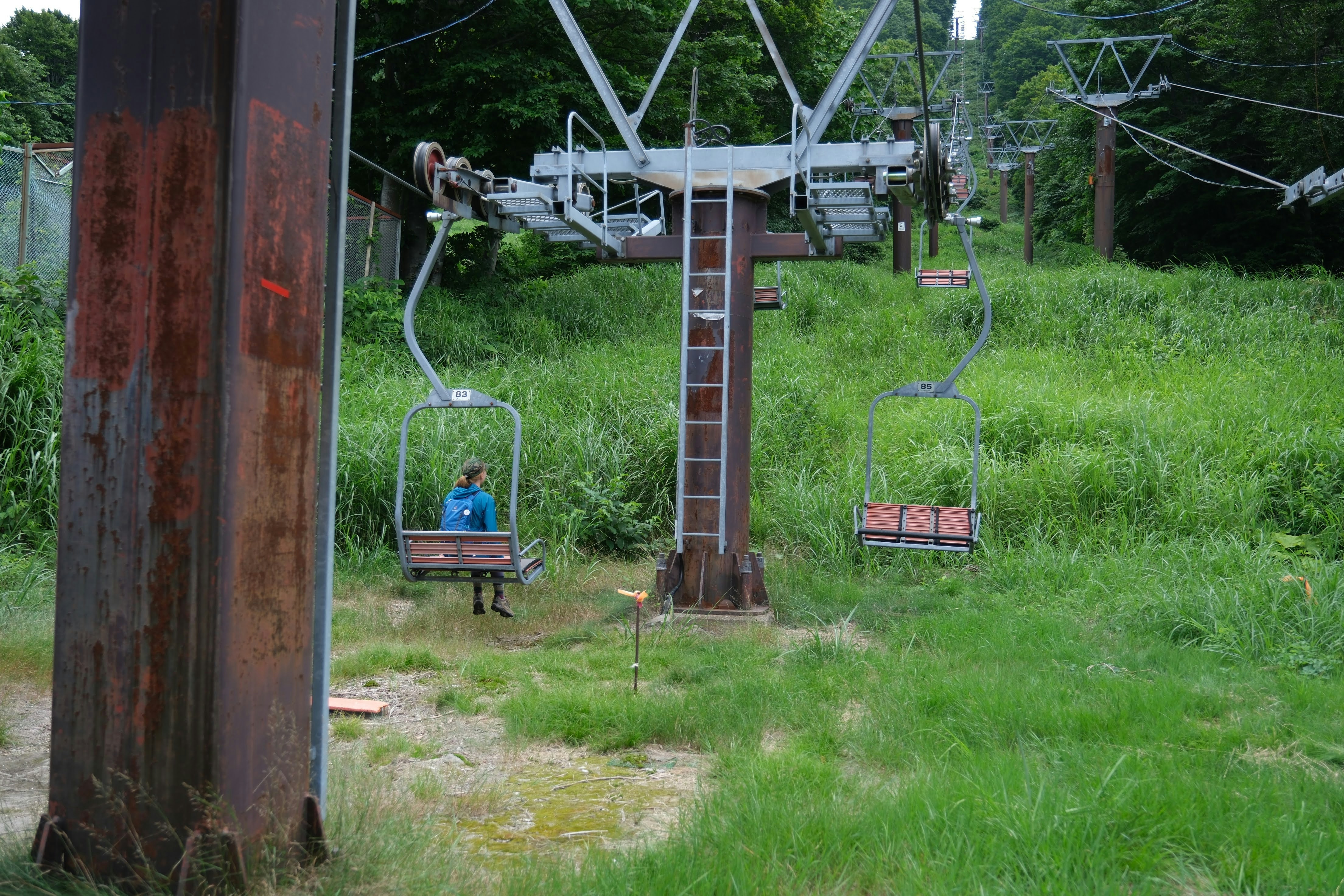 a person sitting on a chair lift in the grass