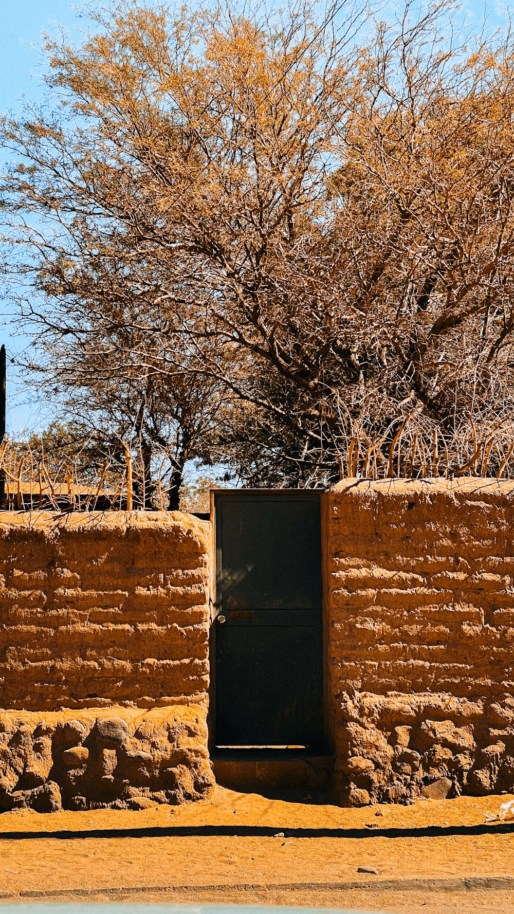 a brown brick wall with a black door