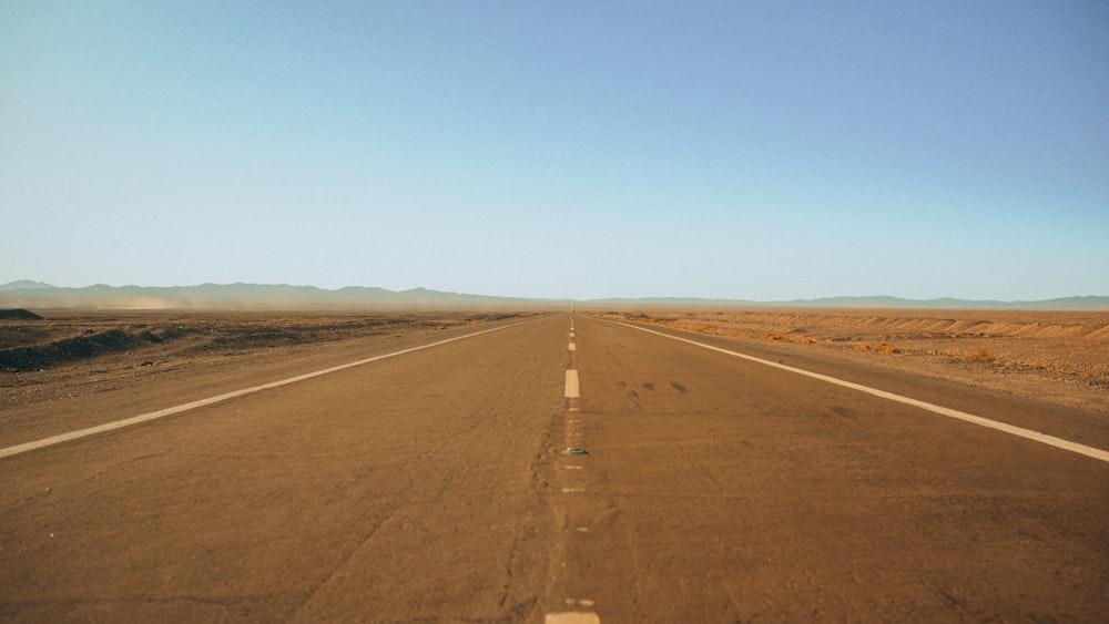 an empty road in the middle of the desert