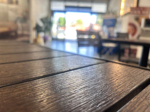 Close-up of a finely crafted wooden café table with golden accents.