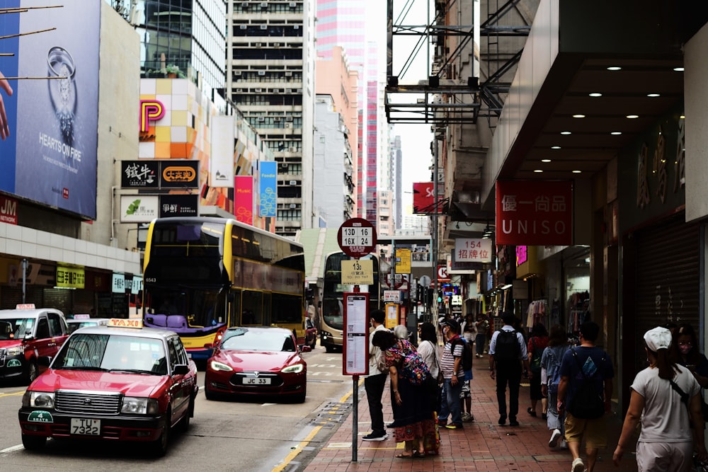 a group of people walking down a street next to tall buildings