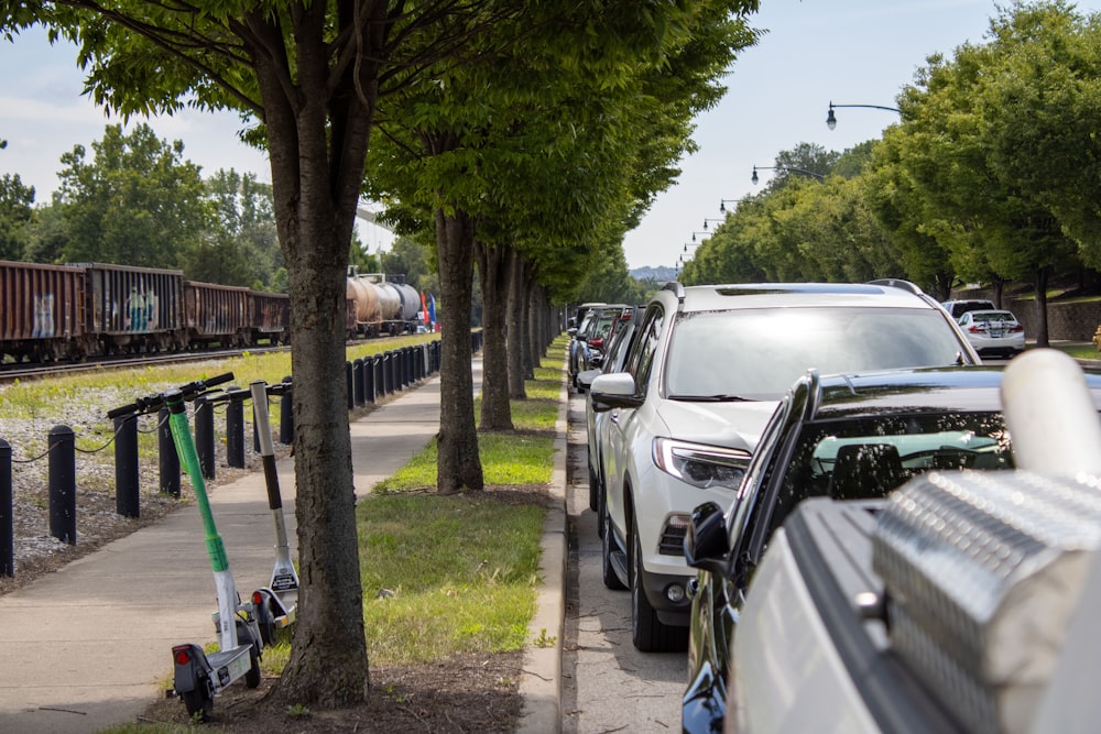 cars parked on the side of the road next to a train track