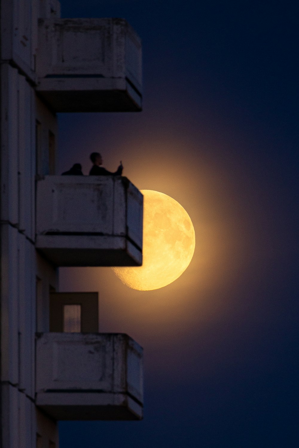 a full moon seen through a window of a building