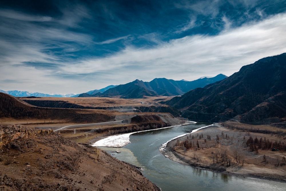 a river running through a valley surrounded by mountains