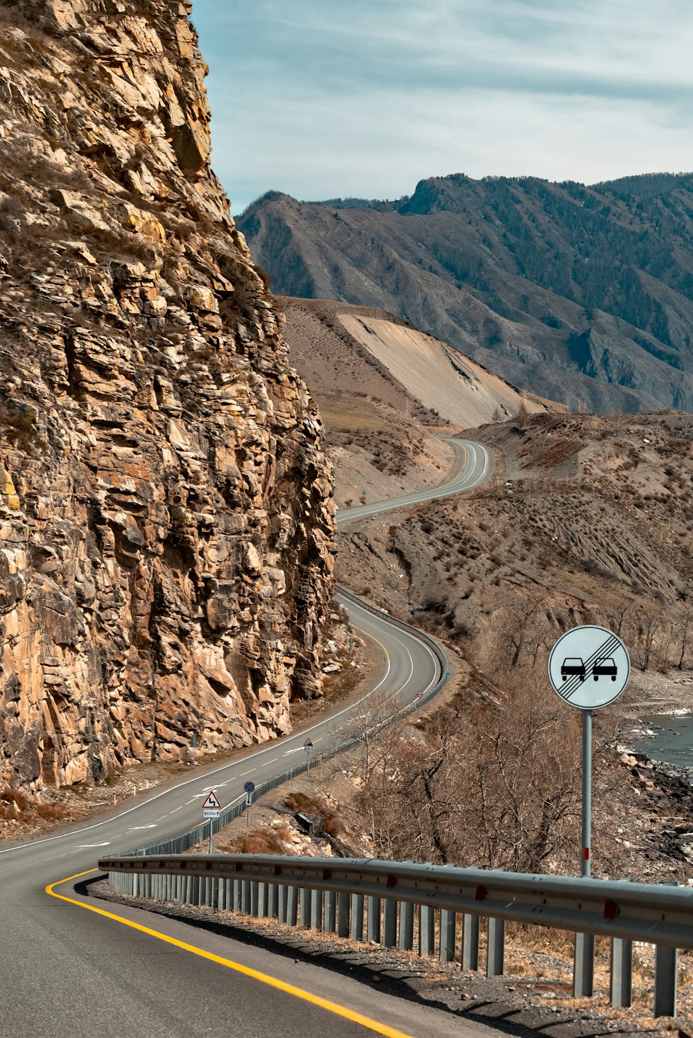 Una carretera que atraviesa una zona montañosa con una montaña al fondo