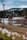 A scenic view of a tranquil forest with a hunting lodge in the background.