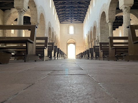 Interior view of a historic synagogue with wooden benches and Torah ark.