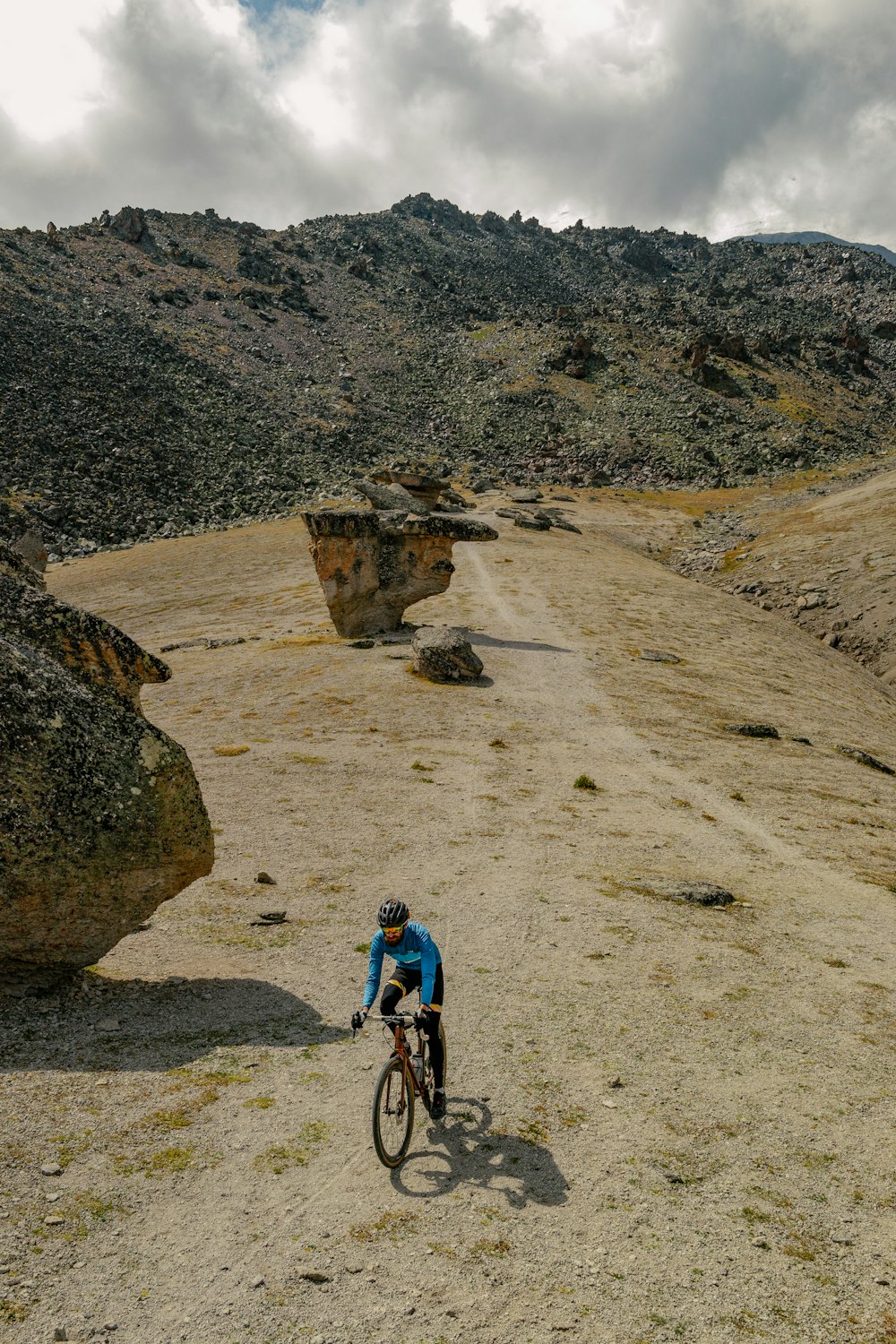 a man riding a bike down a dirt road