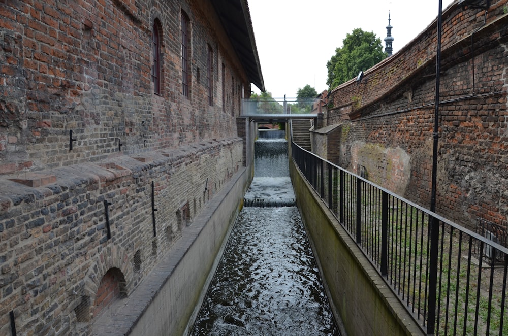 a narrow canal running between two brick buildings