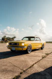 a yellow car parked in a parking lot