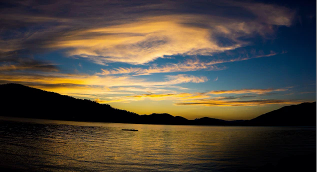Sunset over a serene national park lake with vivid blue skies reflecting on the water.