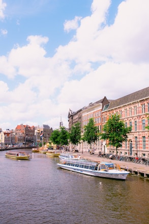 A scenic view of Amsterdam's canals with a cruise boat.