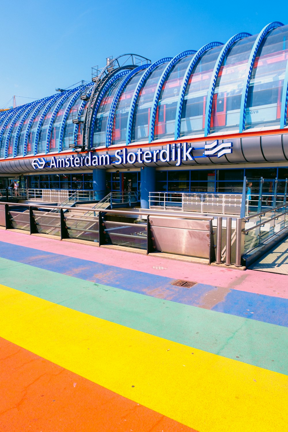 a train station with a rainbow painted walkway