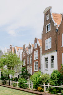 Cozy Dutch townhouse with a small garden in front, bathed in warm afternoon light.