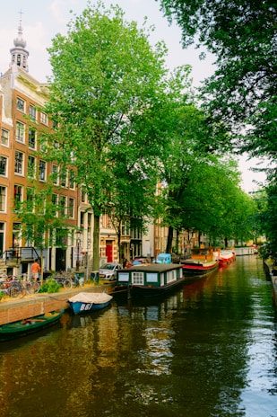 A charming canal in Amsterdam with colorful houseboats and bicycles along the water.